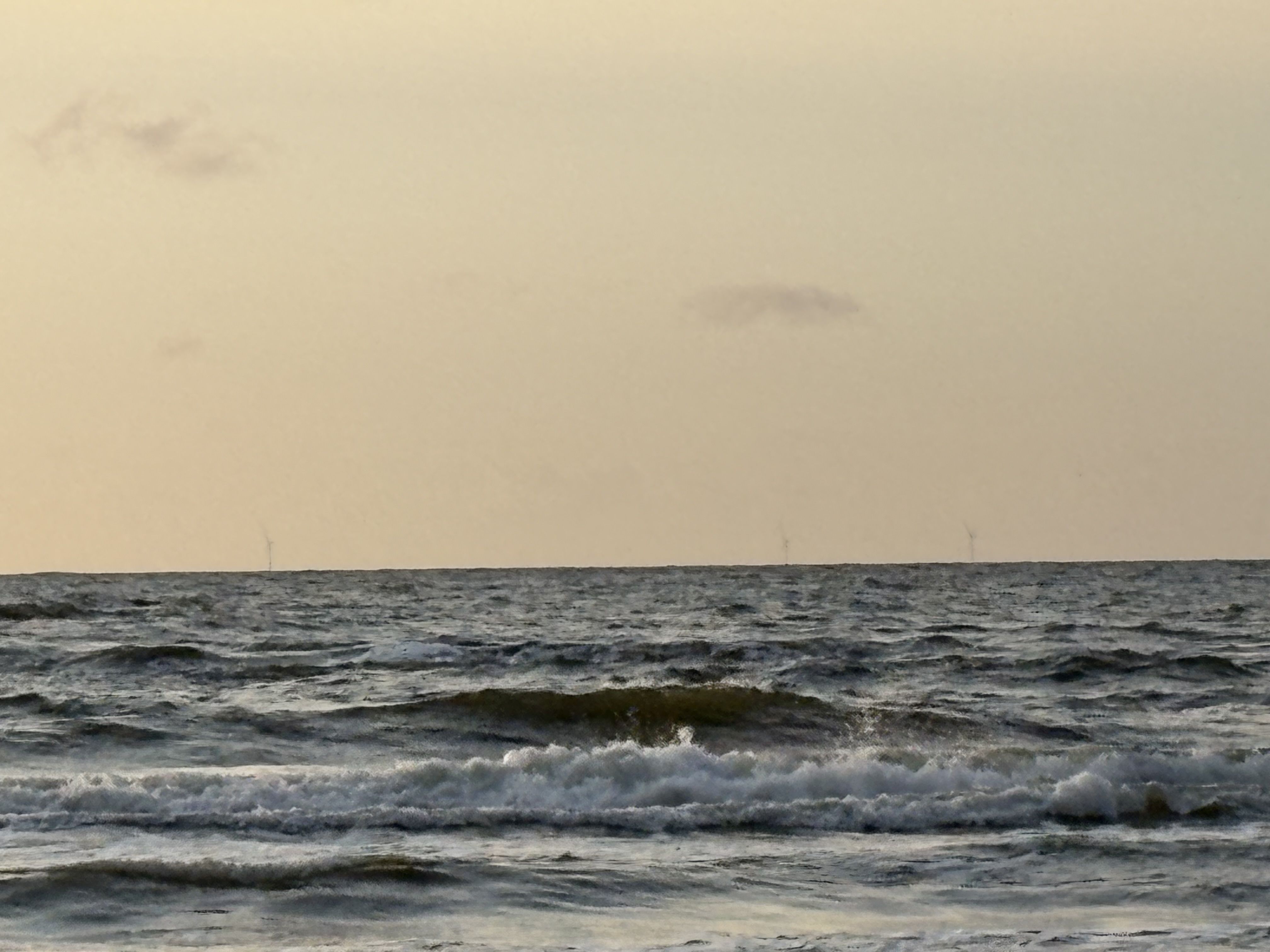 Turbiny wiatrowe farmy Baltic Power widziane z plaży w Lubiatowie